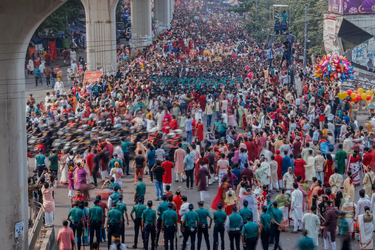 A vast crowd filling a city street during a public procession.