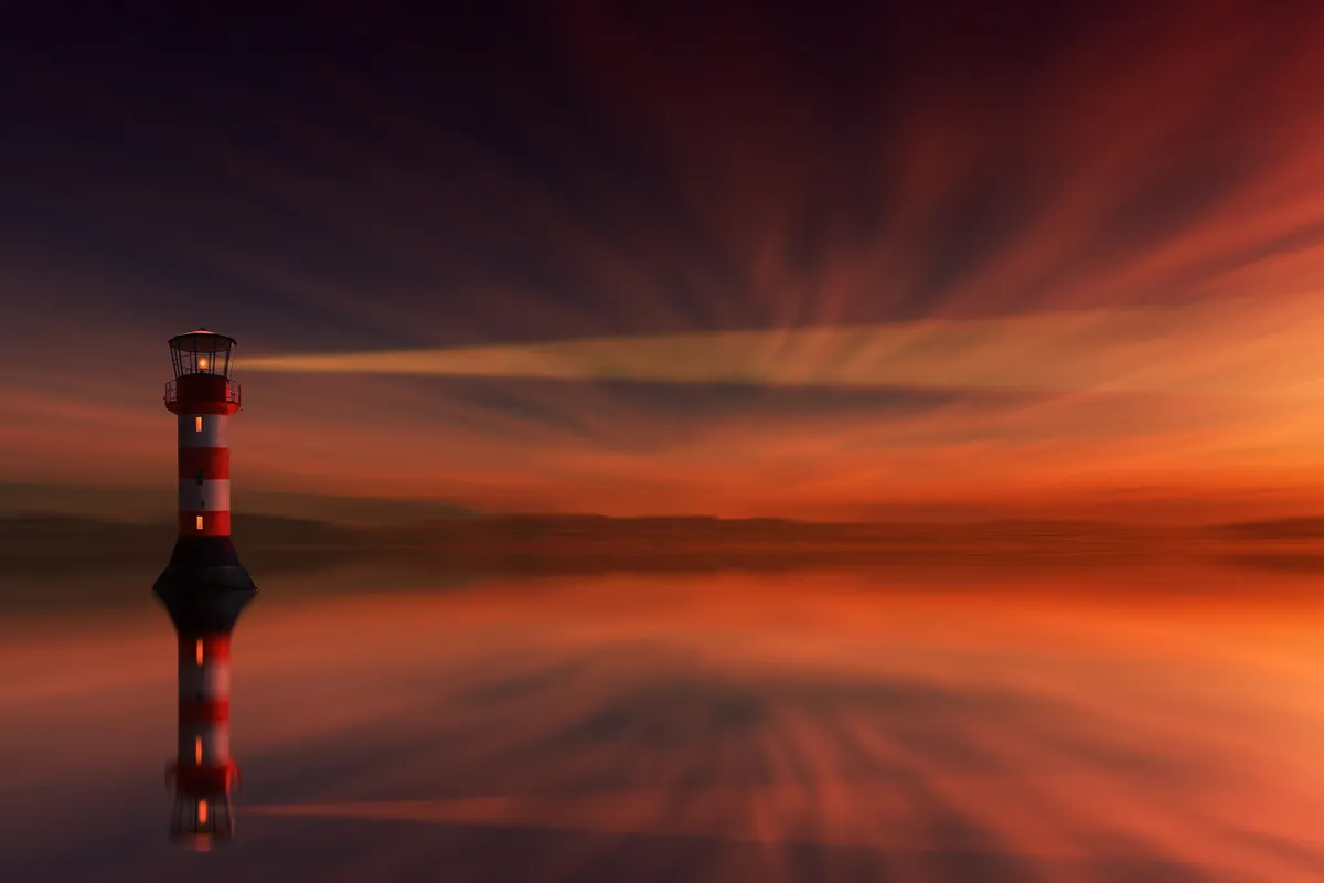 A lighthouse casting its beam over still water at dusk.
