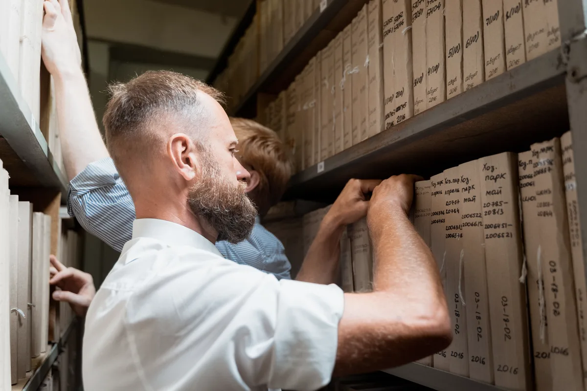 Two archivists handling records in a working archive