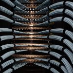 Rows of servers curving through a dark data centre