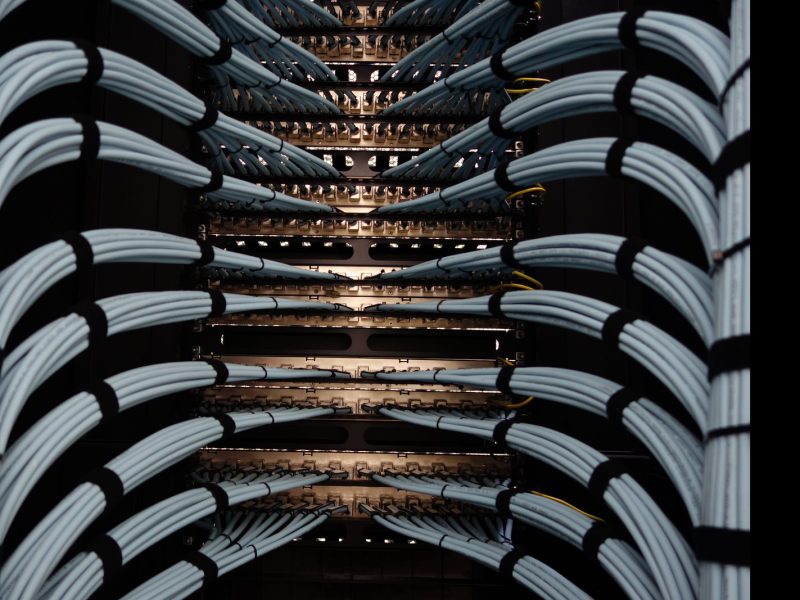 Rows of servers curving through a dark data centre